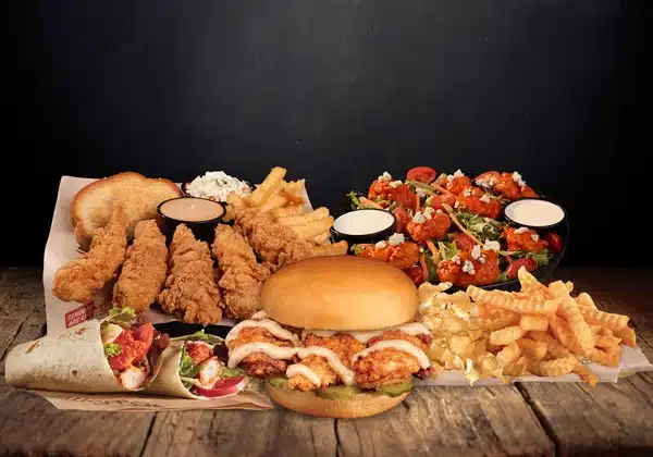 Assortment of Huey Magoo’s menu items including chicken tenders, signature dipping sauces, and sides, showcasing the brand’s handcrafted tenderloin chicken and franchise dining experience.